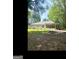 Expansive backyard featuring a screened porch, garden area, stone fire pit, and a serene, wooded backdrop at 180 Tabor Forest Dr, Oxford, GA 30054