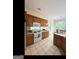 Well-lit kitchen with wooden cabinets, tile flooring, and a white appliance set with a window view at 180 Tabor Forest Dr, Oxford, GA 30054