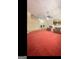 Spacious living room with red carpeting, ceiling fan, and a glimpse into the entry way at 180 Tabor Forest Dr, Oxford, GA 30054
