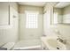 Well-lit bathroom with white tile, glass block window, and updated fixtures at 6770 Burkhead Dr, Union City, GA 30291