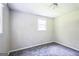 Simple bedroom featuring neutral walls, gray carpet, and a bright window enhancing the overall atmosphere at 6770 Burkhead Dr, Union City, GA 30291