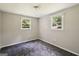Well lit bedroom featuring two windows and neutral colored walls and carpeted floor at 6770 Burkhead Dr, Union City, GA 30291