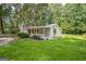 Charming single-story home with a brick chimney, covered porch, and lush green lawn surrounded by mature trees at 6770 Burkhead Dr, Union City, GA 30291