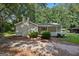 Charming single-story home with a brick chimney, a quaint front porch, and mature landscaping at 6770 Burkhead Dr, Union City, GA 30291