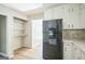 Spacious kitchen featuring a black refrigerator, plenty of cabinet space, and laminate floors throughout at 6770 Burkhead Dr, Union City, GA 30291