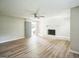Bright living room with a white brick fireplace, new floors, a ceiling fan, and a doorway to the outside at 6770 Burkhead Dr, Union City, GA 30291