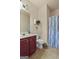 Clean bathroom featuring a vanity, toilet, decorative shelves, and a shower with a vibrant, patterned curtain at 4770 Macy Way, Ellenwood, GA 30294