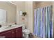 Well-maintained bathroom with a vanity, toilet, decorative shelves, and a shower with a colorful curtain at 4770 Macy Way, Ellenwood, GA 30294
