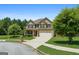 Attractive two-story brick home showcasing lush landscaping, a two-car garage, and a covered front porch at 4770 Macy Way, Ellenwood, GA 30294