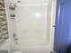 Bathroom with a white shower-tub combo with sliding glass doors and blue door at 4350 Lincolndale Dr, Ellenwood, GA 30294