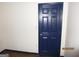 Bedroom featuring light walls, wood floor, and a closed blue door at 4350 Lincolndale Dr, Ellenwood, GA 30294