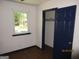 Bedroom featuring light walls, wood floor, blue door, and a window bringing in light at 4350 Lincolndale Dr, Ellenwood, GA 30294