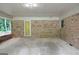 Spacious carport area featuring brick walls, concrete flooring and a yellow exterior door at 4852 Pine Shadows, Stone Mountain, GA 30088