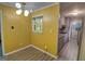 Bright dining area with yellow walls, wood floors, and modern light fixture next to the galley kitchen at 4852 Pine Shadows, Stone Mountain, GA 30088