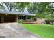 Well-maintained home showcasing a brick facade, covered carport, and lovely landscaping at 4852 Pine Shadows, Stone Mountain, GA 30088