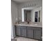 Bathroom featuring double sinks, ample vanity storage, large mirror, and neutral color palette at 1945 Labonte Pkwy # 42, Mcdonough, GA 30253