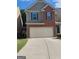 Two-story home with a brick and siding exterior, a two-car garage, and a well-maintained lawn at 1945 Labonte Pkwy # 42, Mcdonough, GA 30253