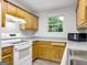 Well-lit kitchen showcasing wooden cabinets, white appliances, and modern flooring at 2039 Faith Cv, Atlanta, GA 30349