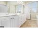 Bathroom with a double sink vanity, white cabinets, and a large mirror at 110 Camford Stone Path, Fayetteville, GA 30214