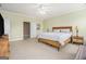 Spacious bedroom with a ceiling fan, a wood frame bed, and light green walls at 110 Camford Stone Path, Fayetteville, GA 30214