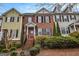 Charming brick townhome featuring a landscaped front yard and a welcoming red front door at 110 Camford Stone Path, Fayetteville, GA 30214