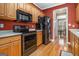 Efficient kitchen design with wood cabinets, stainless steel appliances, and a view to the dining room at 110 Camford Stone Path, Fayetteville, GA 30214