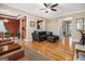 Open concept living room with hardwood floors, a ceiling fan, and views to the dining room at 110 Camford Stone Path, Fayetteville, GA 30214