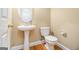 This powder room features a pedestal sink, a toilet, and gold fixtures at 110 Camford Stone Path, Fayetteville, GA 30214