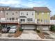 Rear view of attached townhomes with decks and garages, and small trees in the driveways at 110 Camford Stone Path, Fayetteville, GA 30214