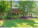 Classic brick home with manicured lawn, professional landscaping, and mature trees at 200 Savannah Walk, Peachtree City, GA 30269