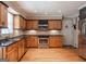 Well-lit kitchen featuring stainless steel appliances, wooden cabinets, and hardwood floors at 200 Savannah Walk, Peachtree City, GA 30269