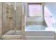 Bathroom features a tub, separate glass shower, and a window with blinds for natural light at 2817 Village Park E Dr, Ellenwood, GA 30294