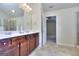 Spacious bathroom boasts dual sinks with dark wood cabinetry and a view into the connecting bedroom at 2817 Village Park E Dr, Ellenwood, GA 30294