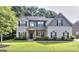 Charming two-story home with well-manicured lawn, complemented by lush landscaping and mature trees at 2817 Village Park E Dr, Ellenwood, GA 30294