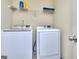 A functional laundry room equipped with a modern washer and dryer set with a storage shelf at 2817 Village Park E Dr, Ellenwood, GA 30294