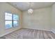 Bright living room with plush carpet, large window, and decorative chandelier, offering a cozy and inviting space at 2817 Village Park E Dr, Ellenwood, GA 30294