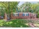 Charming brick home with blue shutters, surrounded by mature trees and a lush green lawn at 1737 Cahoon Sw St, Atlanta, GA 30310