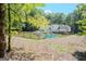 Expansive backyard with a sparkling blue swimming pool, surrounded by a wooden fence, and manicured landscaping at 360 Darren Dr, Fayetteville, GA 30215