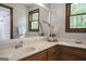 Double sink bathroom featuring wooden cabinets, large mirror, and natural light at 360 Darren Dr, Fayetteville, GA 30215