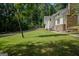 Charming home exterior with a stone chimney, surrounded by lush greenery, and a spacious yard, creating a serene setting at 360 Darren Dr, Fayetteville, GA 30215