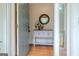 A foyer features a stylish table with decor, a round mirror, and hardwood floors at 360 Darren Dr, Fayetteville, GA 30215
