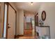 Inviting hallway featuring hardwood floors, a staircase, and a decorative table with an oval mirror at 360 Darren Dr, Fayetteville, GA 30215