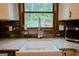 Close up on a farmhouse style kitchen sink with a view of the backyard through the window at 360 Darren Dr, Fayetteville, GA 30215