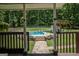 A view of the fenced in pool from the deck, surrounded by manicured lawn and lush greenery at 360 Darren Dr, Fayetteville, GA 30215