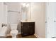 White bathroom with tile floors, a dark wood vanity, a toilet, a towel rack and a modern light fixture at 416 Fairway Dr, Acworth, GA 30101
