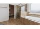 Bathroom showcasing a glass shower and soaking tub with neutral tile, plus a walk-in closet entrance at 416 Fairway Dr, Acworth, GA 30101