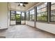Enclosed sunroom with neutral paneled walls, tile floors, black framed windows and a ceiling fan at 416 Fairway Dr, Acworth, GA 30101