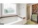Bright bathroom featuring a soaking tub with ledge, mosaic-style window, and glass-enclosed shower at 186 Ashley Dr, Mcdonough, GA 30252