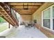 An outdoor patio with an exposed wood ceiling, brick walls, and seating for six at 186 Ashley Dr, Mcdonough, GA 30252