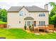 Back exterior showcasing a wooden deck, a well-manicured lawn, and lush greenery at 4311 Hampton Mill Pkwy, Douglasville, GA 30135